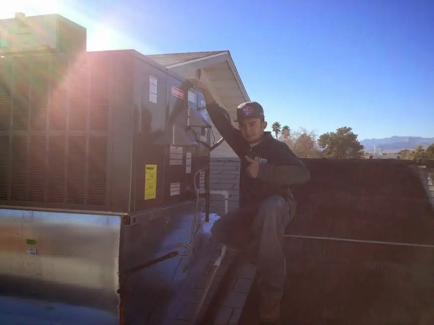 HVAC technician performing Boiler Repair on a rooftop unit in Milltown